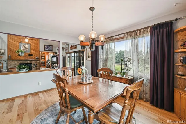 a dining room with furniture a chandelier and wooden floor