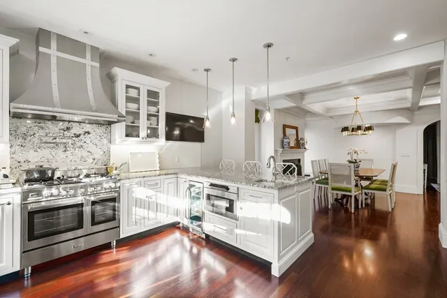 a living room with stainless steel appliances granite countertop furniture wooden floor and a view of kitchen