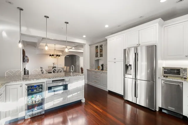 a kitchen with stainless steel appliances a refrigerator and wooden floor