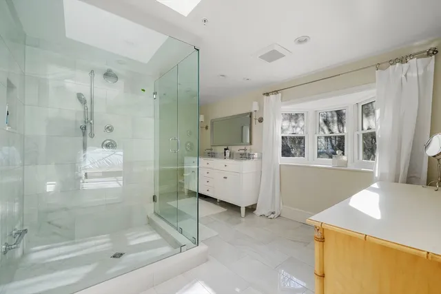 a bathroom with a bathtub sink and mirror