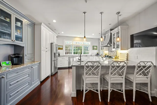 a view of a dining room and livingroom with furniture wooden floor a chandelier