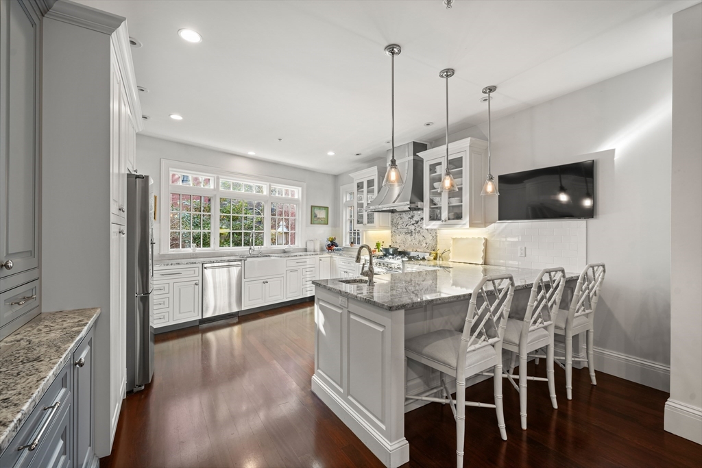 3 Mount Vernon Square, Unit 2 Boston, MA 02108 - Photo 9 of 33 a kitchen with stainless steel appliances granite countertop a stove top oven a sink a dining table and chairs with wooden floor