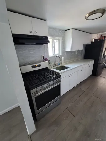 a kitchen with granite countertop a stove and a sink