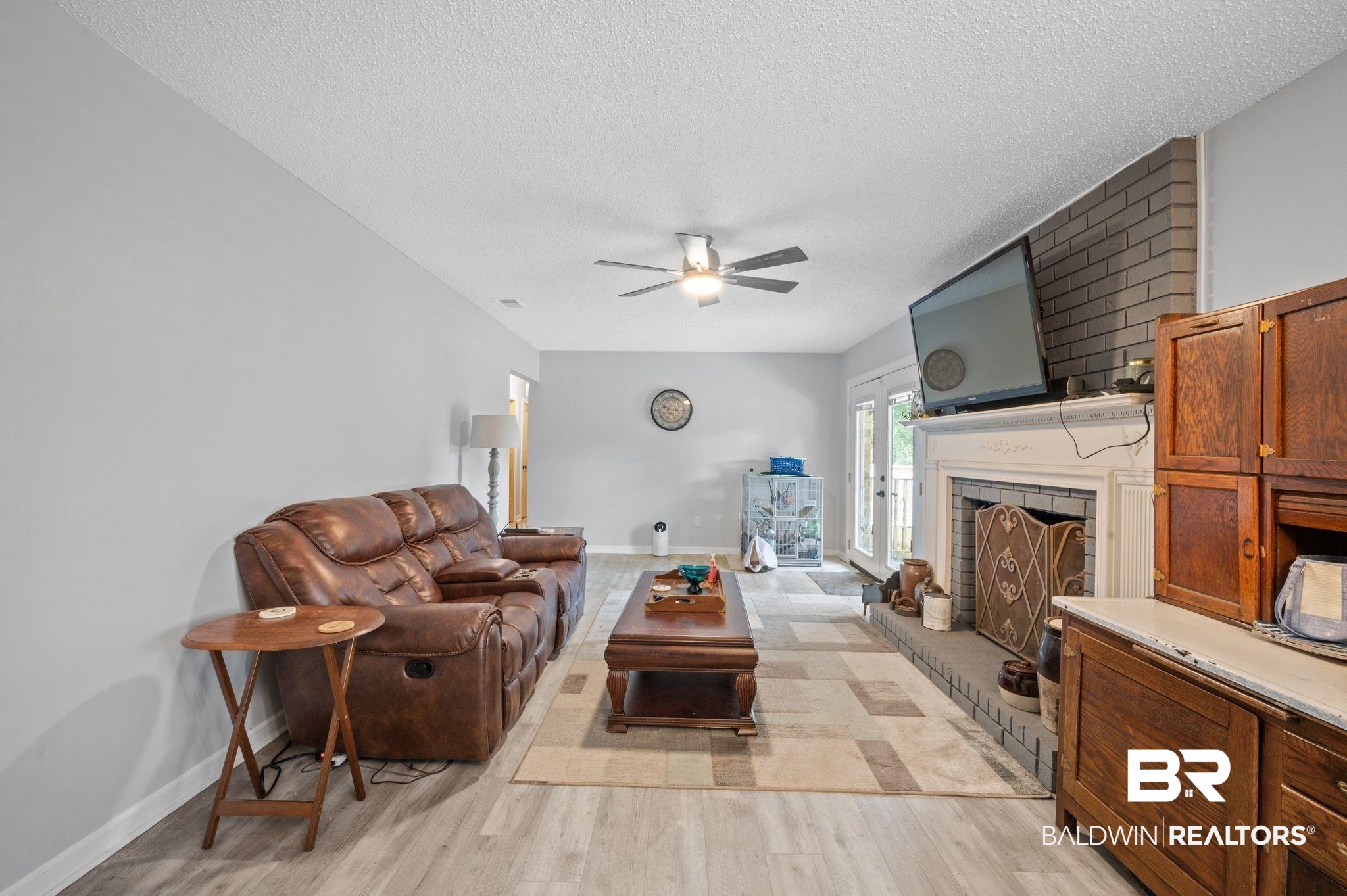 620 Southern Way Spanish Fort, AL 36527 - Photo 4 of 18 Living room with a textured ceiling, light hardwood / wood-style flooring, a fireplace, and ceiling fan
