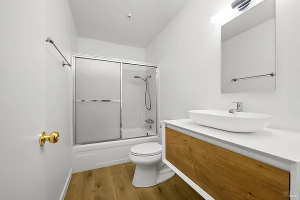 a bathroom with a sink a toilet and shower