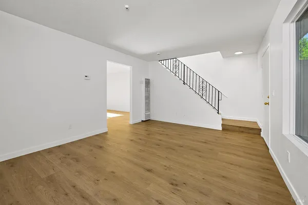 a view of an empty room with wooden floor