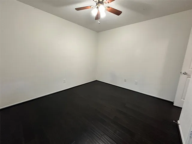 an empty room with wooden floor and window