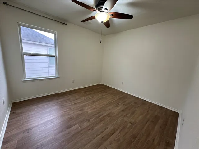 a small space with a wooden floor and a window