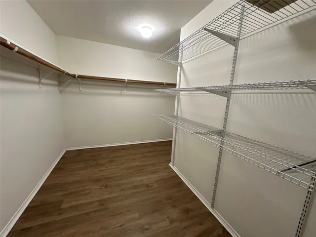 an empty room with wooden floor and cabinet