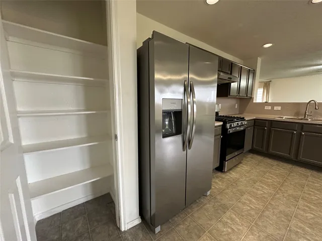 a view of a hallway with a kitchen