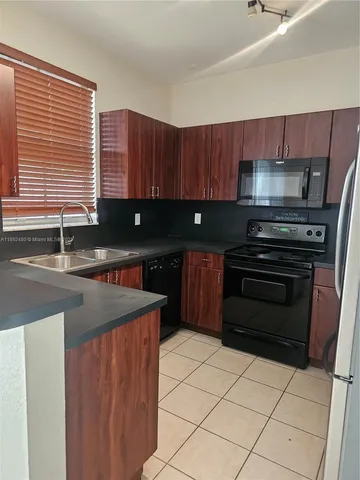 a kitchen with stainless steel appliances granite countertop a refrigerator stove and microwave