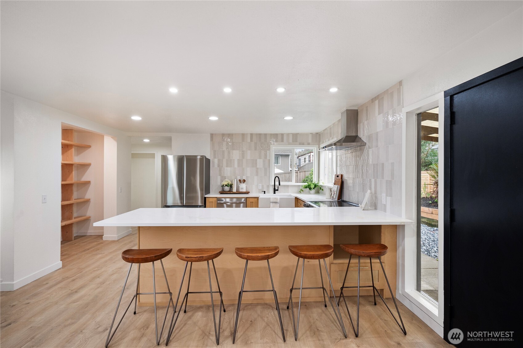 1406 Shattuck Avenue South Renton, WA 98055 - Photo 5 of 22 a kitchen with stainless steel appliances a dining table chairs and wooden cabinets