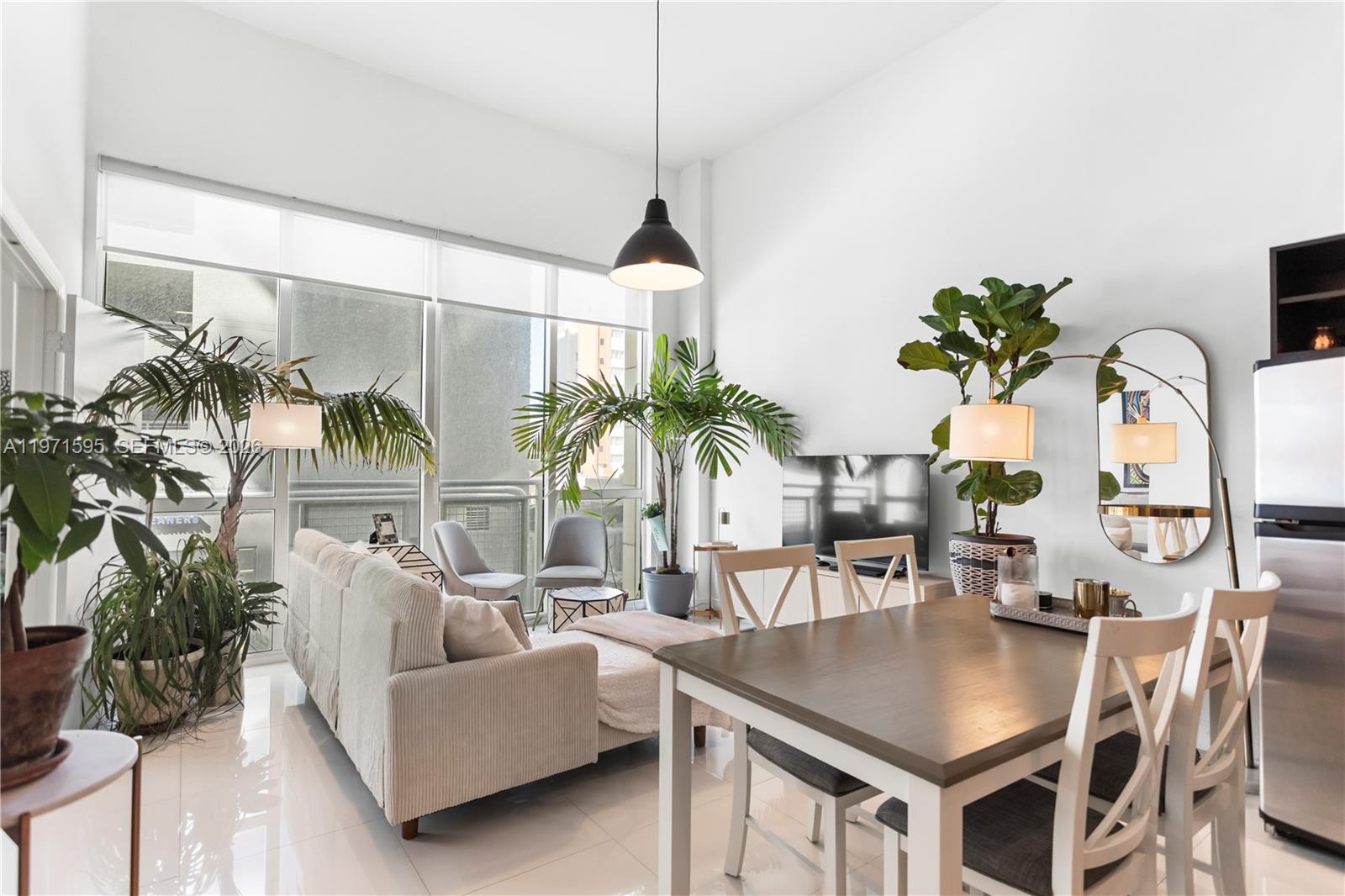 244 Biscayne Boulevard, Unit 252 Miami, FL 33132 - Photo 5 of 18 a dining room with furniture potted plants and wooden floor
