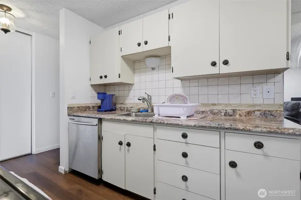 a kitchen with granite countertop white cabinets and white appliances