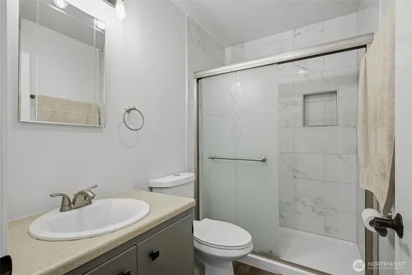 a bathroom with a granite countertop toilet sink and shower