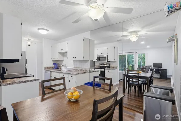 a open dining room with stainless steel appliances kitchen island granite countertop furniture and a kitchen view