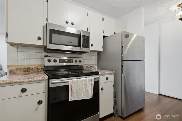 a kitchen with stainless steel appliances a refrigerator stove and microwave