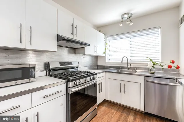 a kitchen with granite countertop white cabinets and white stainless steel appliances
