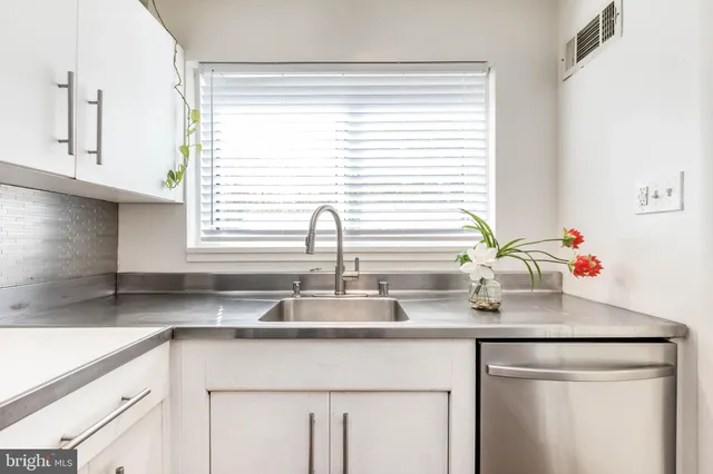 a kitchen with kitchen island a sink a counter appliances and a counter top space