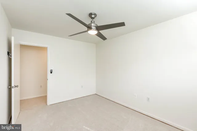 an empty room with a ceiling fan and a window