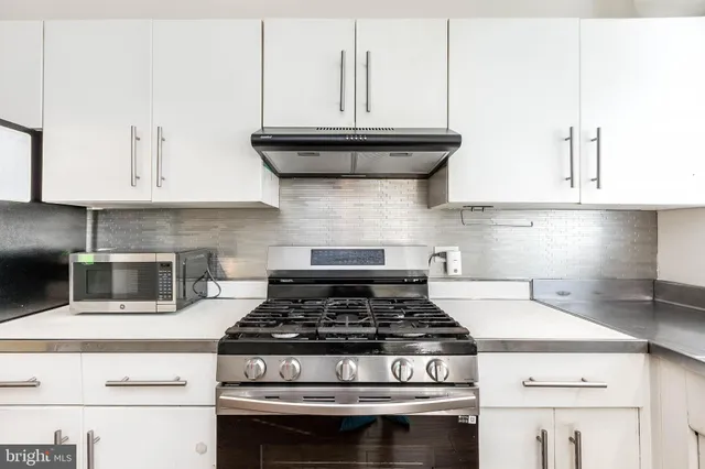 a stove top oven sitting inside of a kitchen