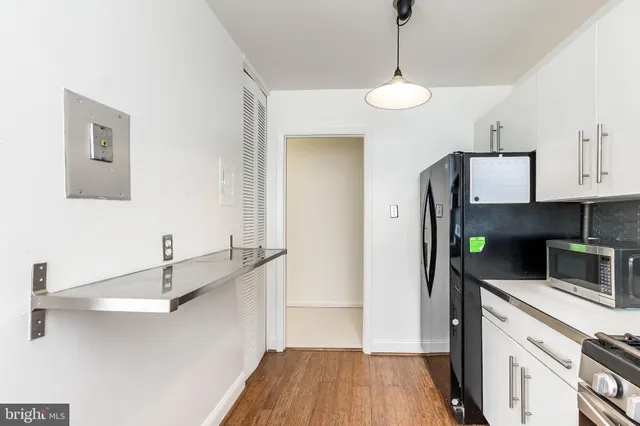 a kitchen with stainless steel appliances a stove a refrigerator and cabinets