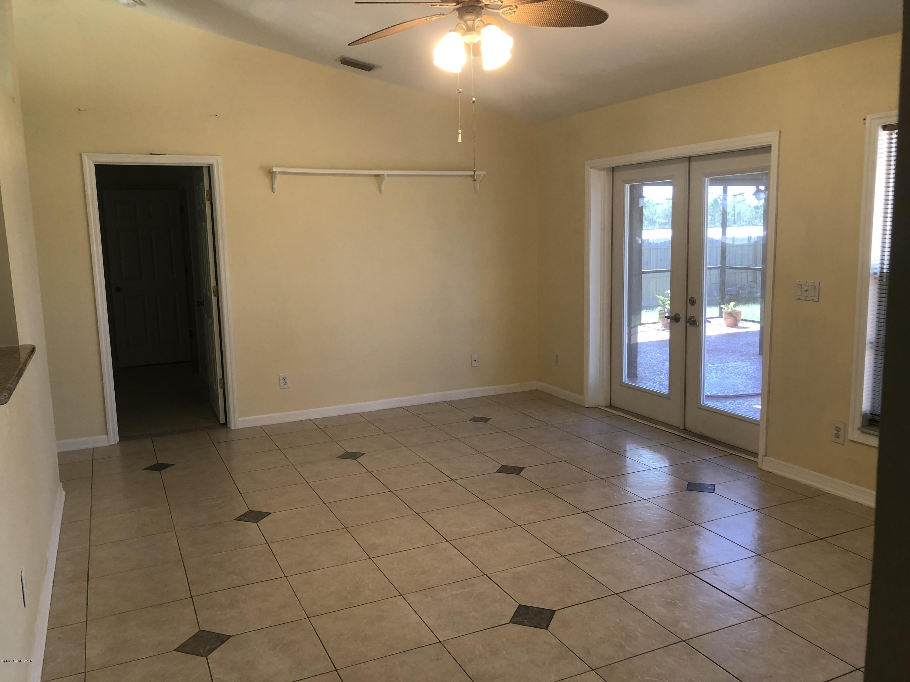 969 Ray Road Southeast Palm Bay, FL 32909 - Photo 5 of 22 a view of an empty room with window and chandelier