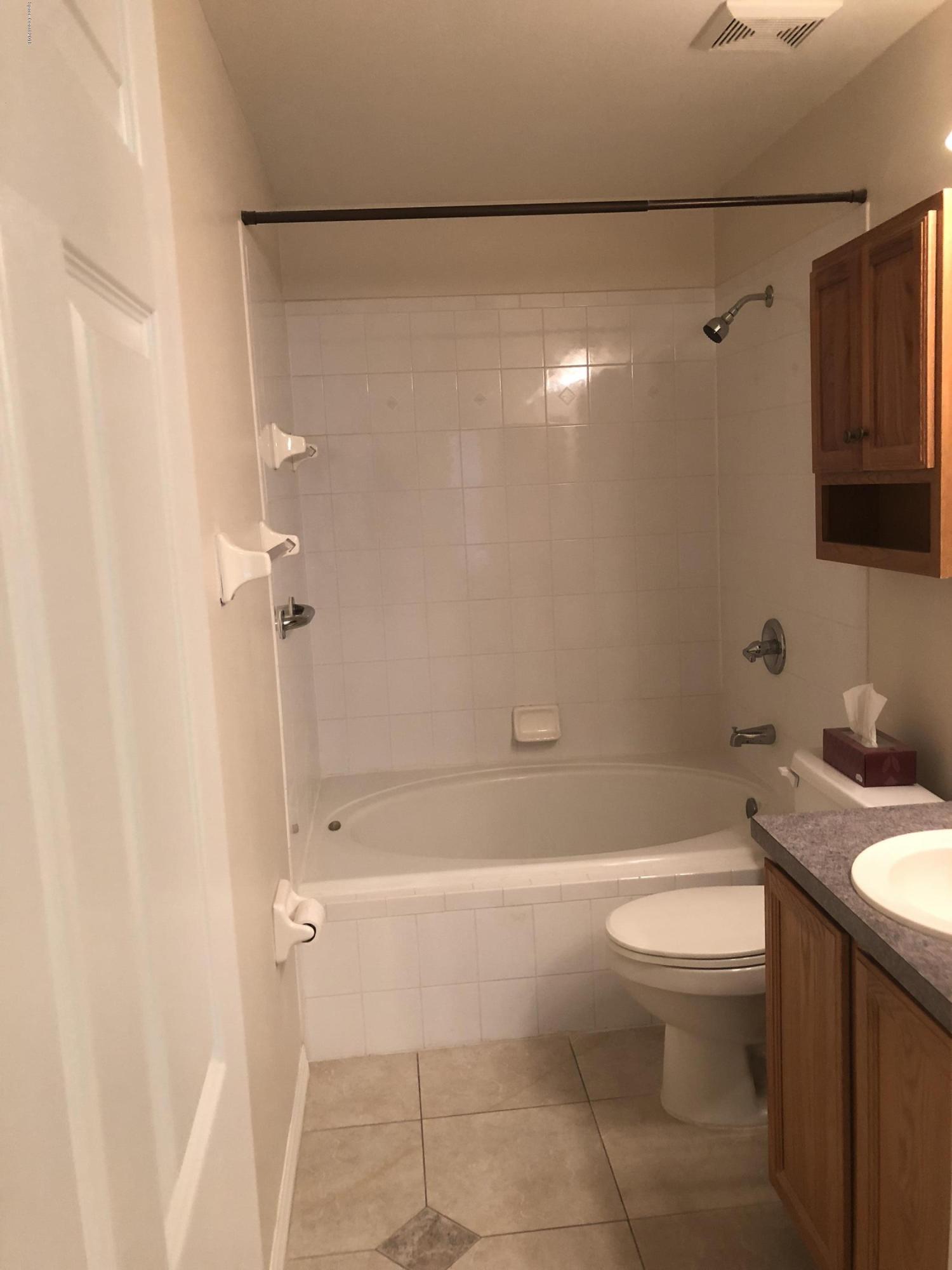 969 Ray Road Southeast Palm Bay, FL 32909 - Photo 8 of 22 a bathroom with a granite countertop bathtub shower sink vanity and toilet