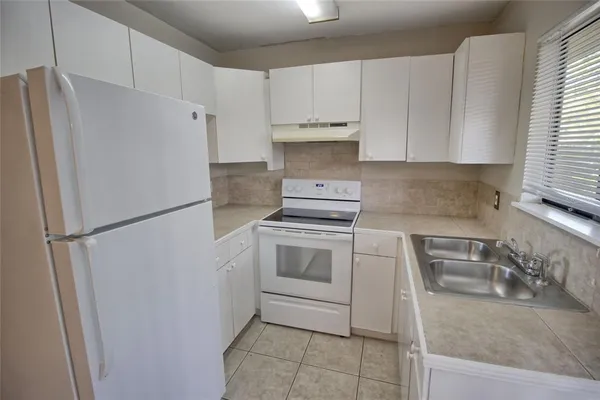 a kitchen with a refrigerator sink and cabinets