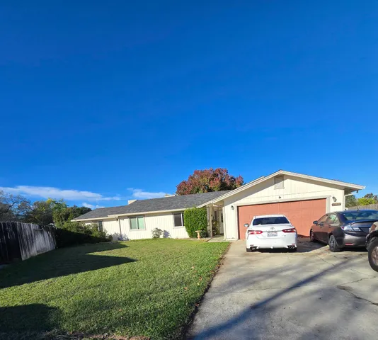 a view of a car parked in front of a house with a yard