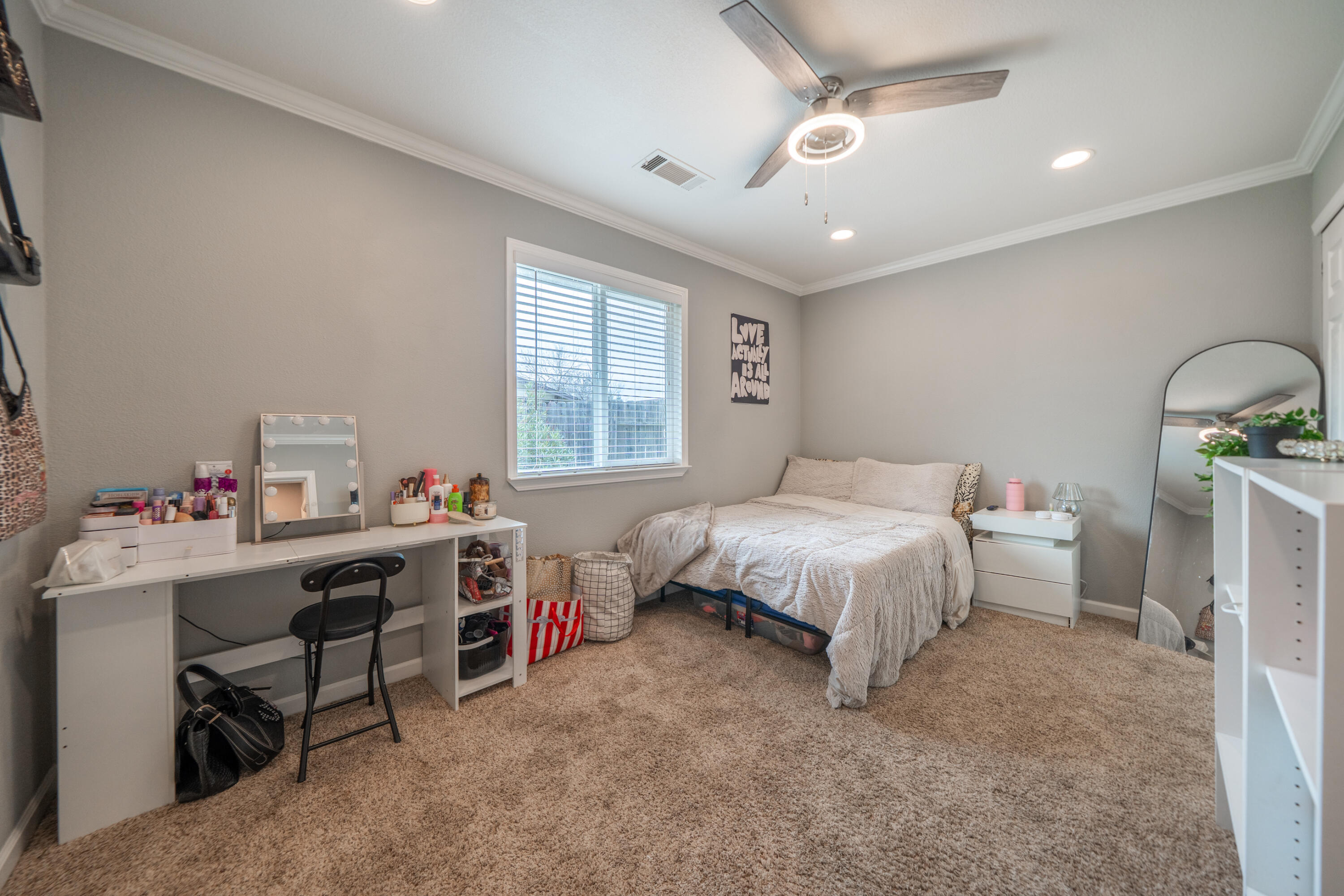 1070 Dara Court Redding, CA 96003 - Photo 22 of 66 a bedroom with a bed a desk and a chandelier