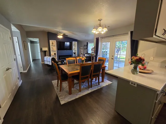 a view of a dining room with furniture a chandelier and wooden floor