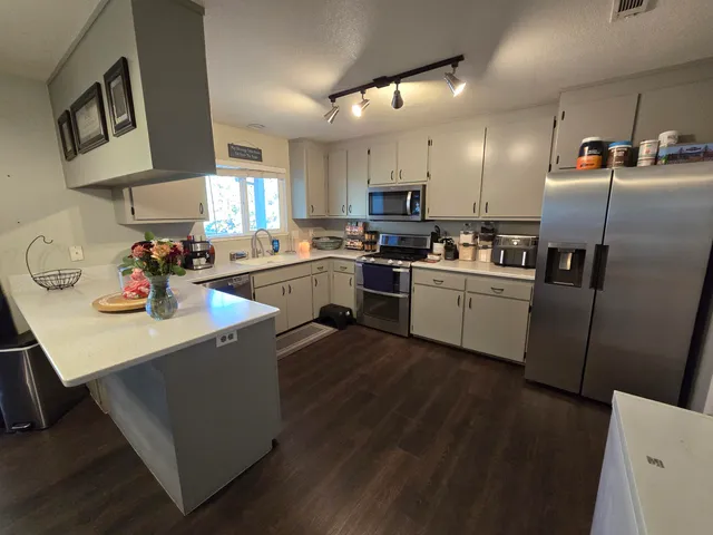 a kitchen with cabinets a sink a stove and refrigerator