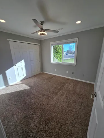 en empty room with windows and ceiling fan