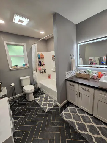 a spacious bathroom with a double vanity sink mirror and toilet