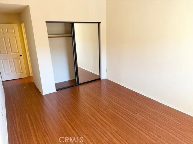 an empty room with wooden floor and entrance