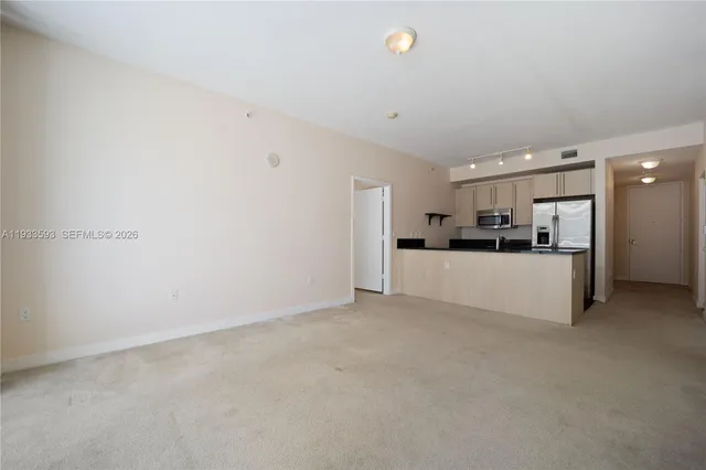 a view of a kitchen with a refrigerator and a sink