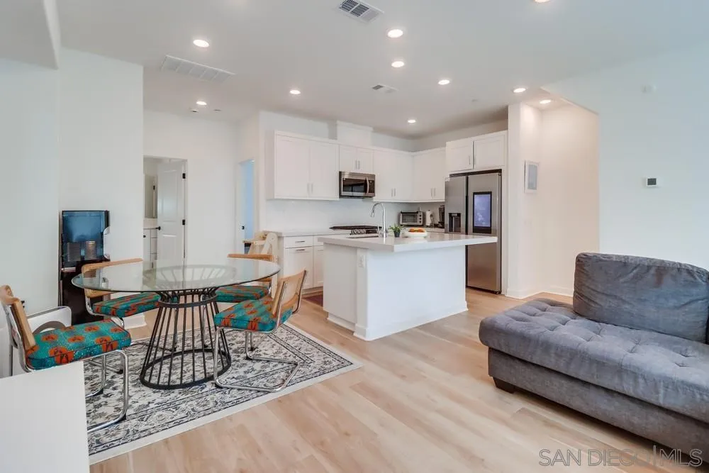 a living room with stainless steel appliances granite countertop furniture a kitchen a sink a stove a dining table and chairs