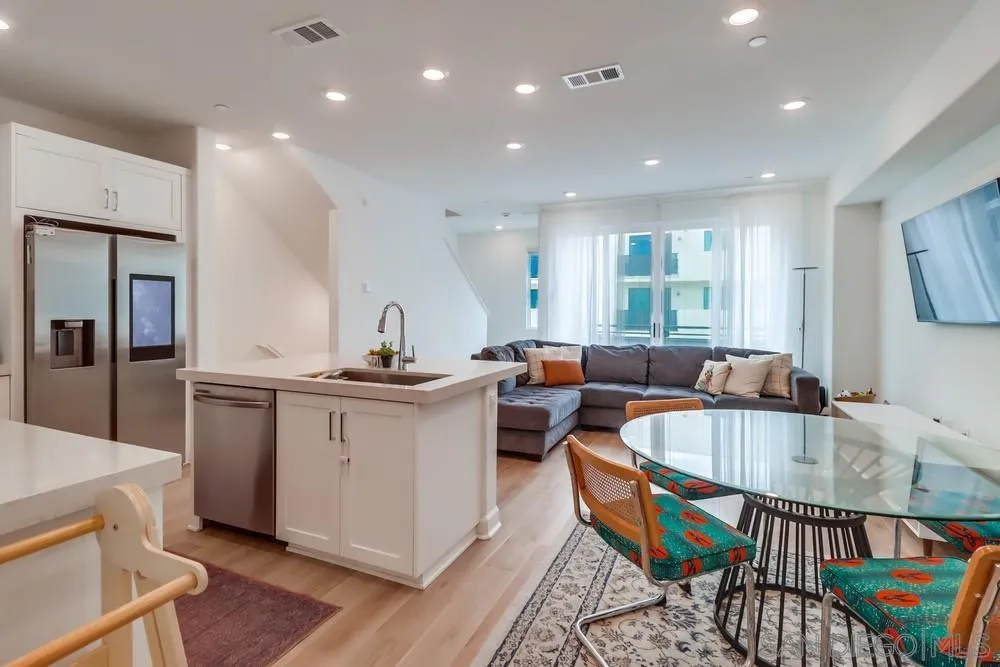 2408 Cascalote Loop San Diego, CA 92154 - Photo 13 of 50 a kitchen with stainless steel appliances granite countertop a sink a stove a dining table and chairs