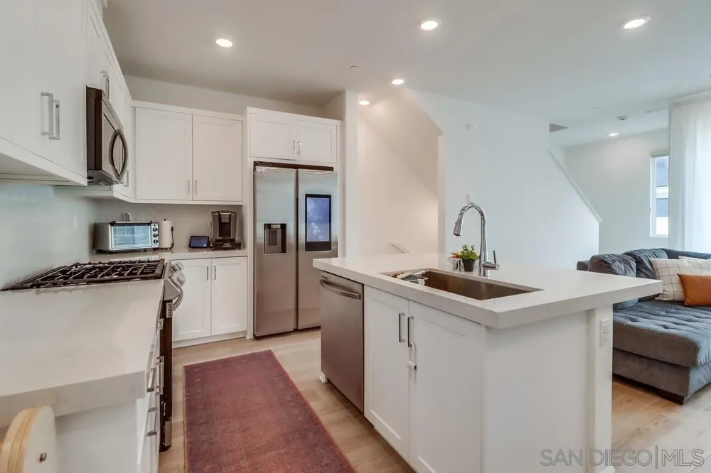 2408 Cascalote Loop San Diego, CA 92154 - Photo 14 of 50 a kitchen with stainless steel appliances a sink stove and refrigerator