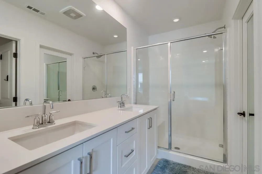 2408 Cascalote Loop San Diego, CA 92154 - Photo 28 of 50 a bathroom with a double vanity sink mirror and shower