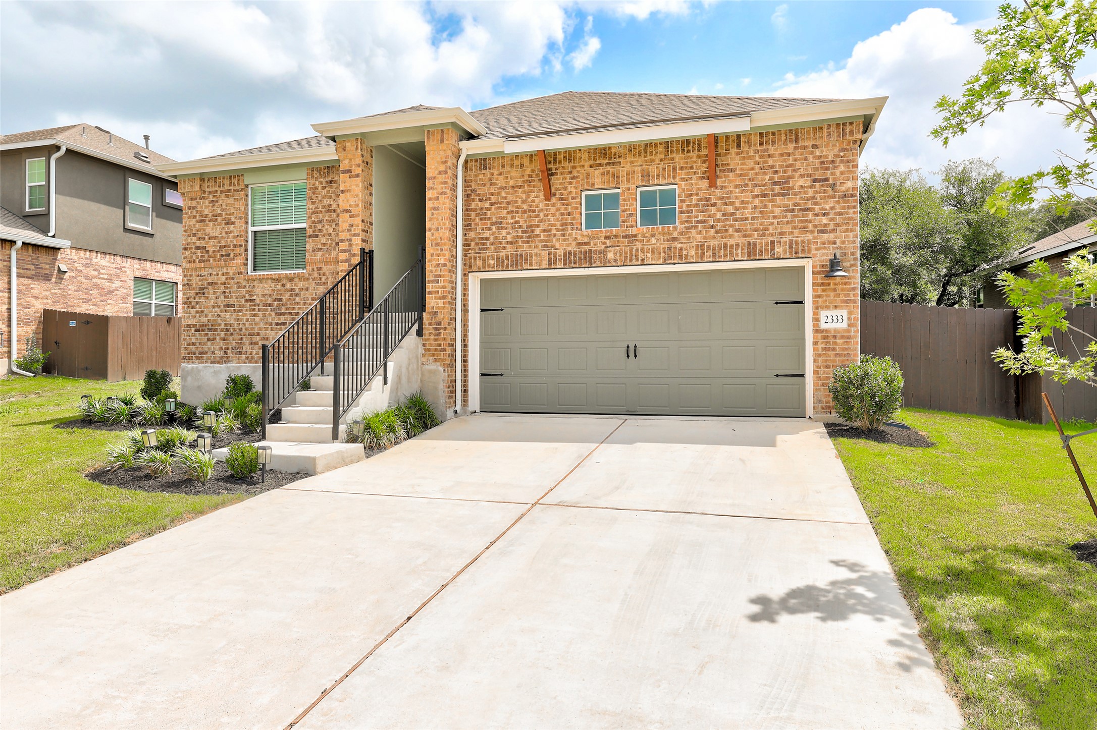 2333 Four Waters Loop Georgetown, TX 78628 - Photo 3 of 35 Brick facade residence featuring a two-car garage with carriage-style hardware