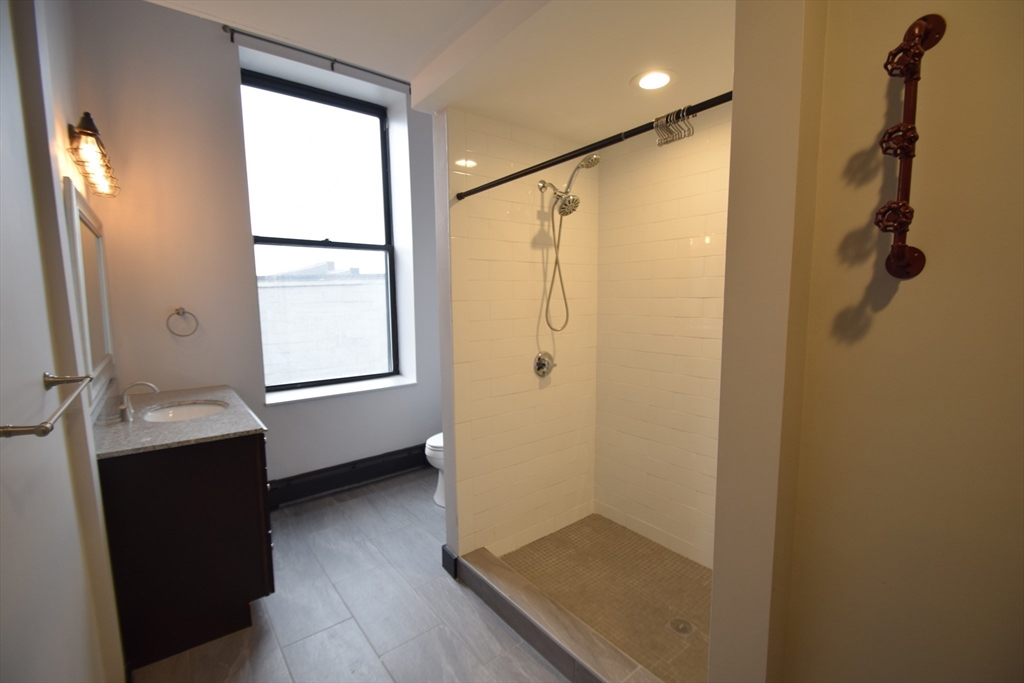 444 Western Avenue, Unit 3 Boston, MA 02135 - Photo 5 of 11 a bathroom with a shower and a sink