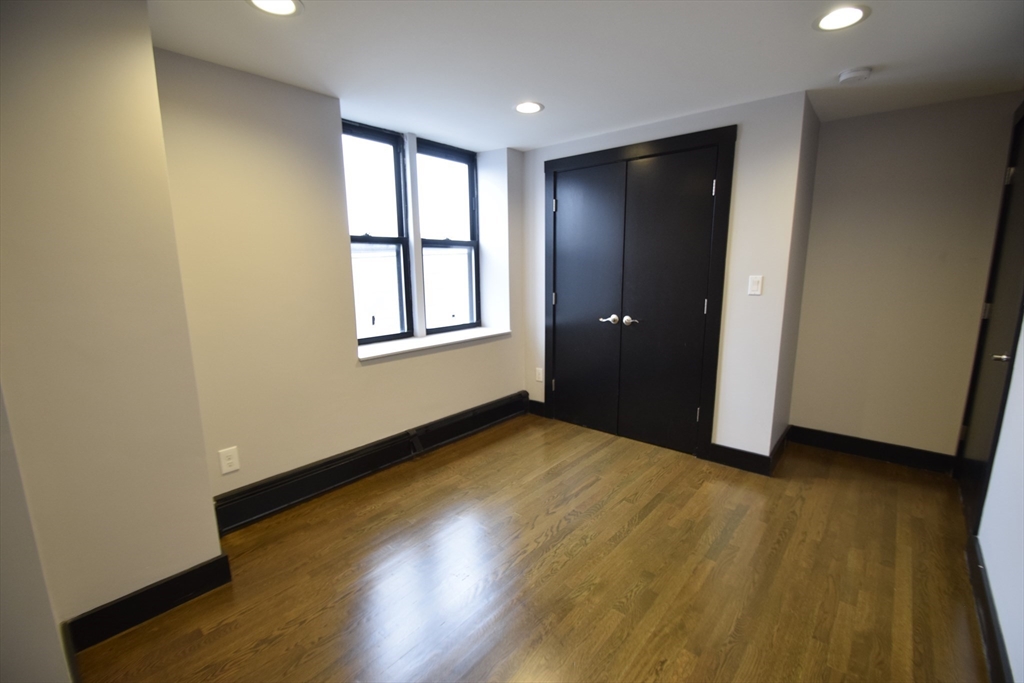 444 Western Avenue, Unit 3 Boston, MA 02135 - Photo 8 of 11 an empty room with wooden floor and windows