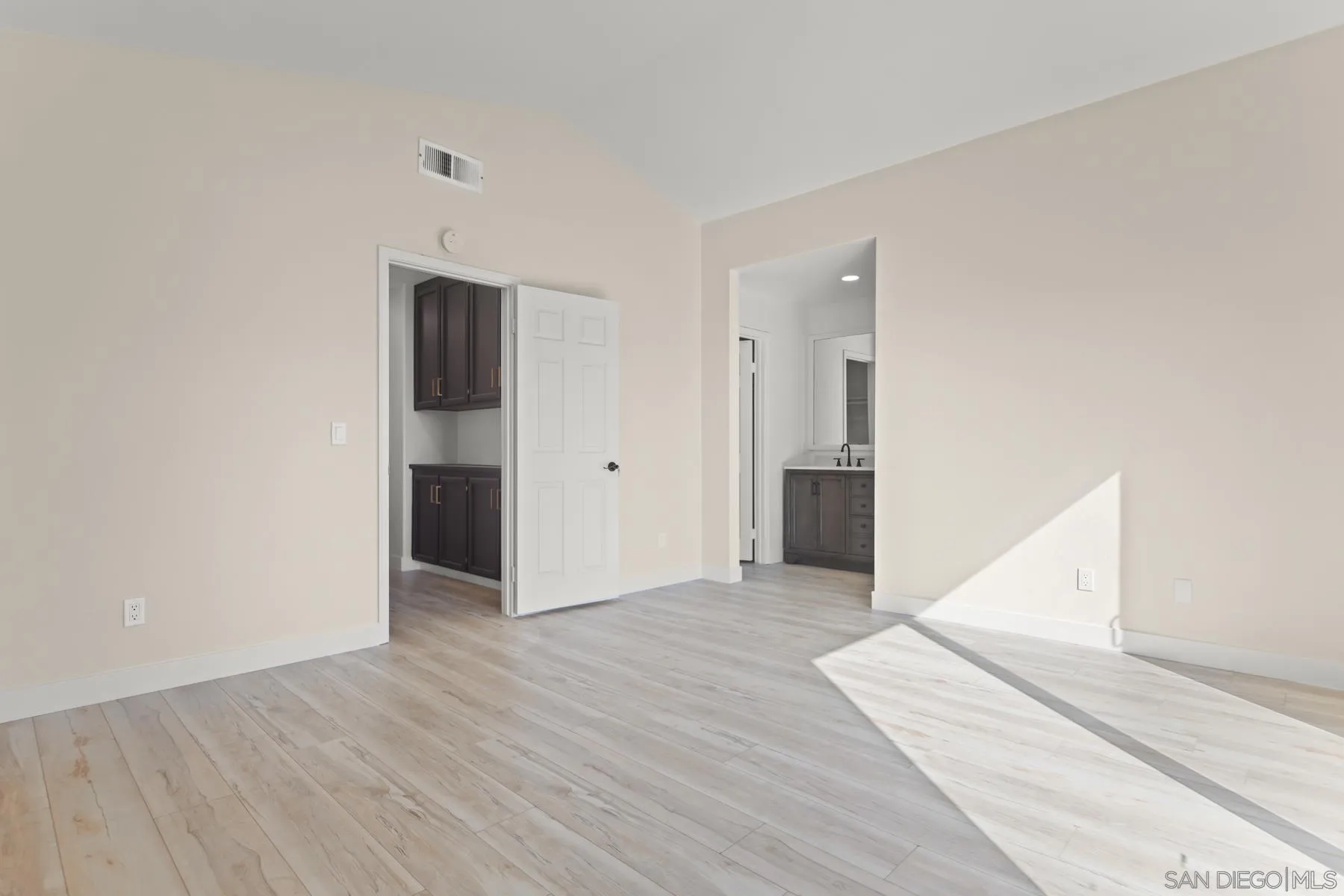 10167 Bluestone Court Spring Valley, CA 91977 - Photo 23 of 49 a view of an empty room with wooden floor and a kitchen