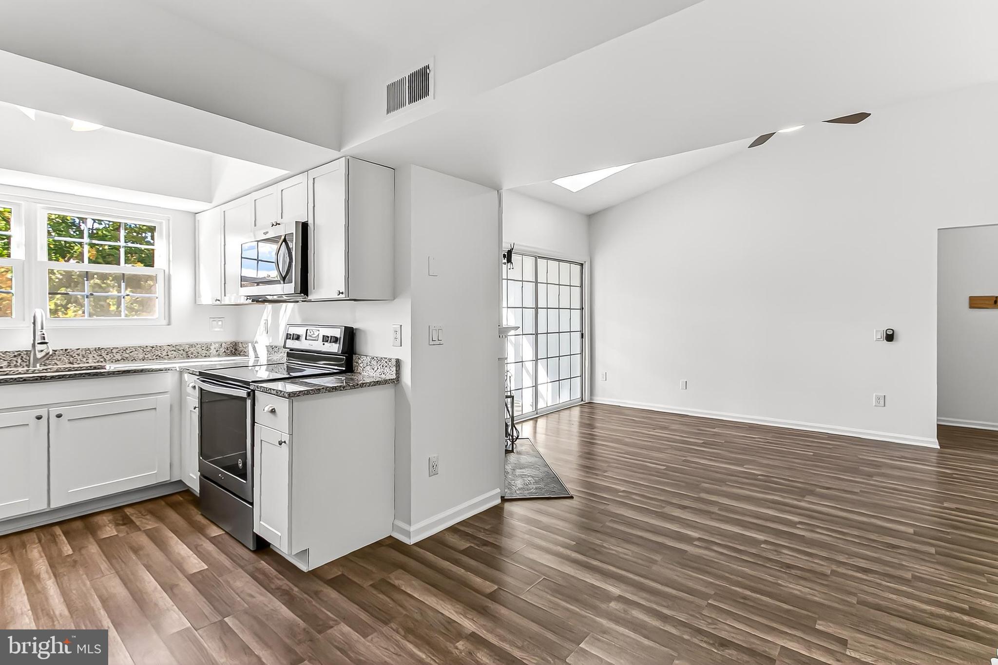 120 Prosperity Avenue Southeast, Unit E Leesburg, VA 20175 - Photo 16 of 34 a kitchen with wooden floors and white appliances