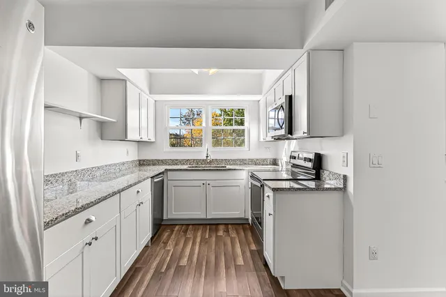 a kitchen with granite countertop a sink and a stove