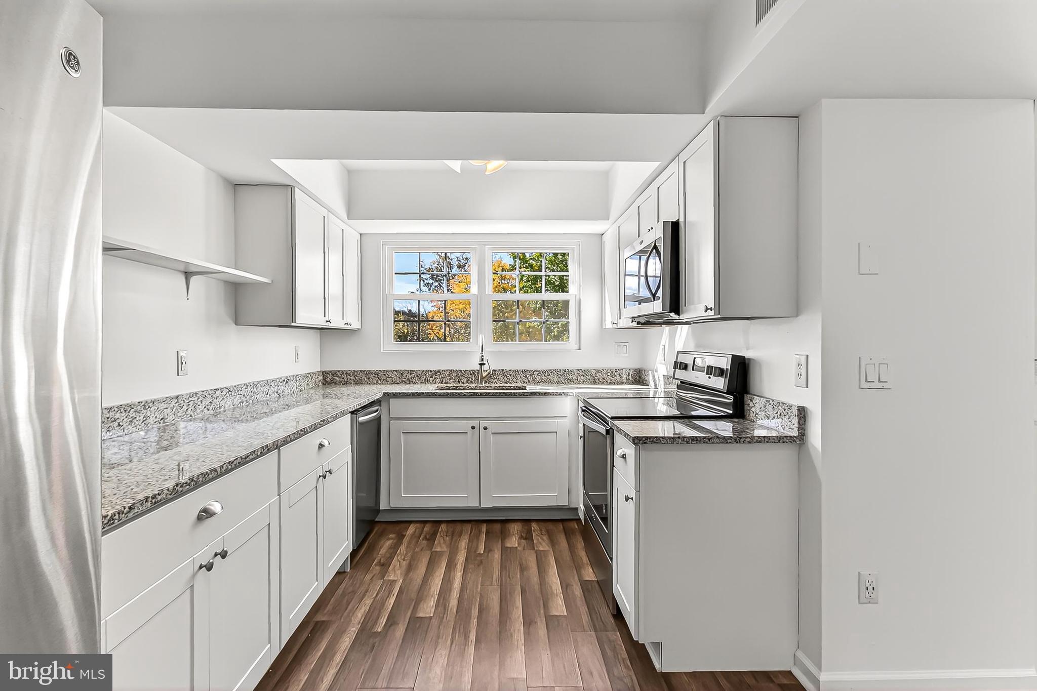 120 Prosperity Avenue Southeast, Unit E Leesburg, VA 20175 - Photo 17 of 34 a kitchen with granite countertop stainless steel appliances a sink stove top oven and cabinets