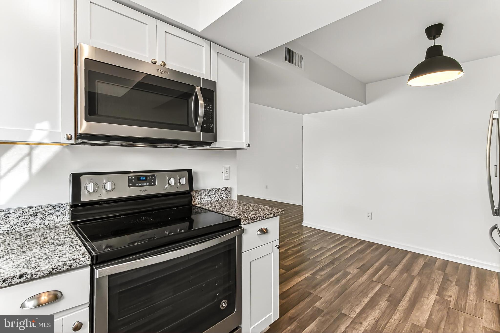 120 Prosperity Avenue Southeast, Unit E Leesburg, VA 20175 - Photo 19 of 34 a kitchen with a stove and a microwave