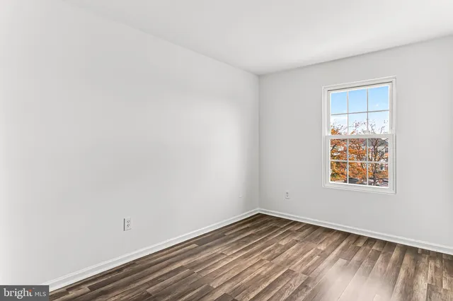 a view of a room with wooden floor and white doors
